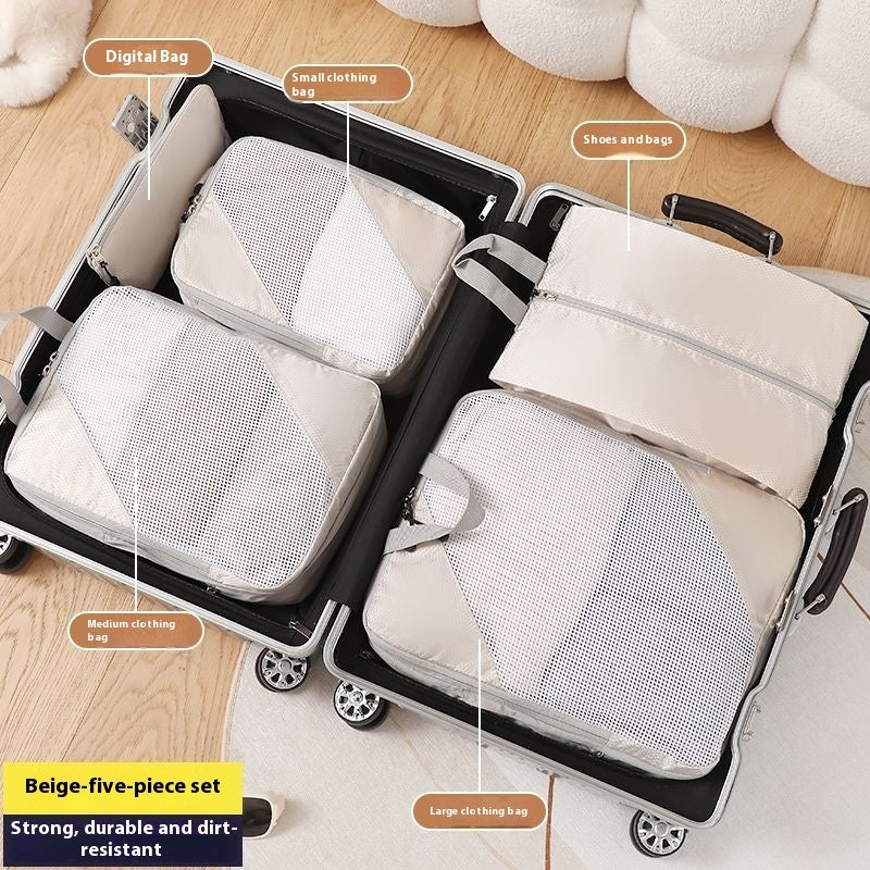Set of beige mesh packing cubes labeled for different uses inside an open suitcase.