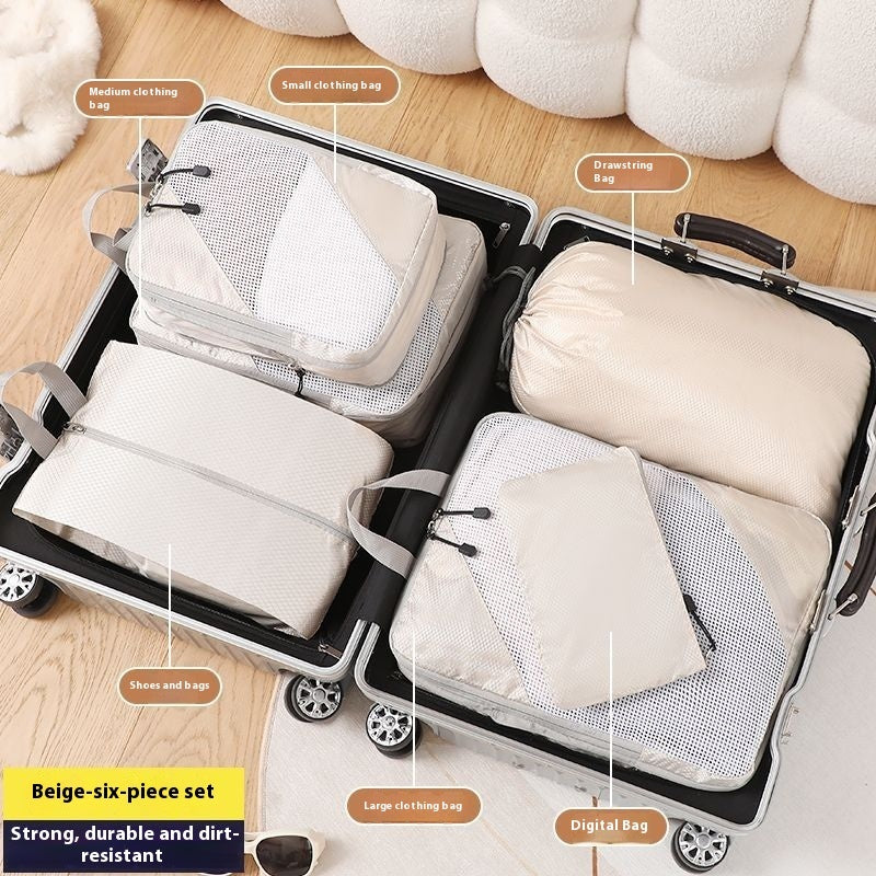 Set of beige packing cubes labeled with their uses inside an open suitcase.