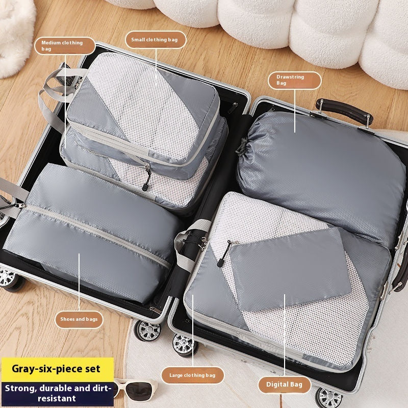 Gray packing cubes labeled with their uses on a suitcase.