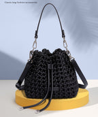 Black woven bucket bag on a yellow stand with a light blue background and text 'NEW.FASHION#' above.