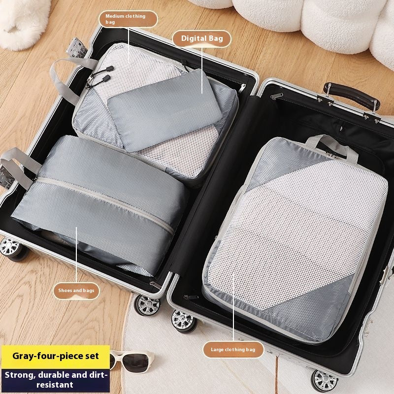 Gray packing cubes labeled with their uses on a suitcase.