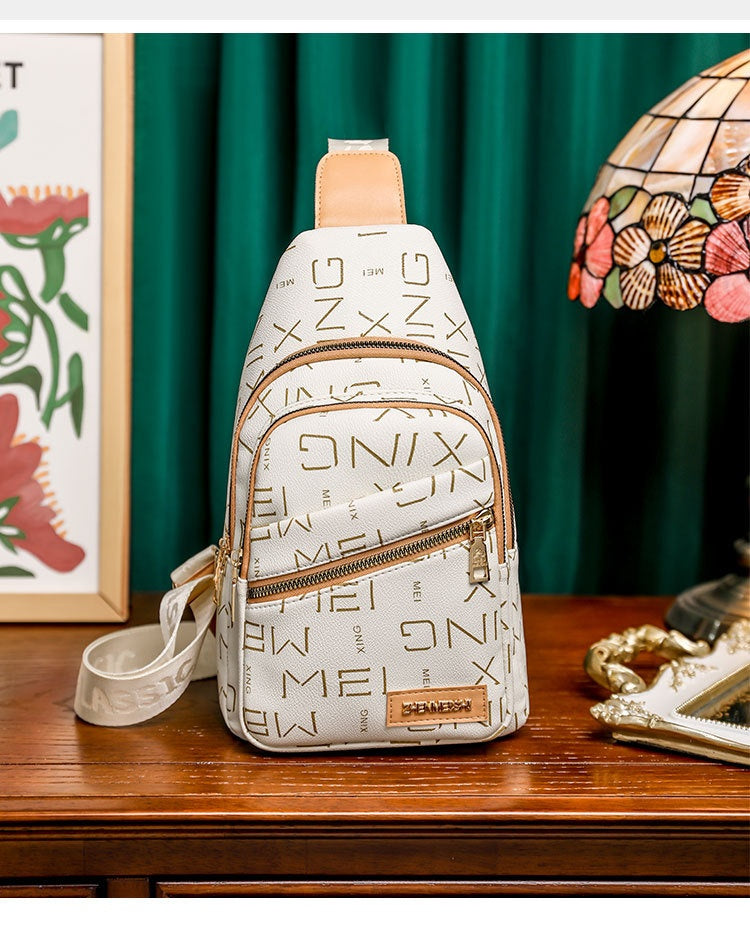 White sling bag with gold lettering on a wooden surface with decorative background