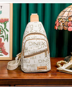 White sling bag with gold lettering on a wooden surface with decorative background